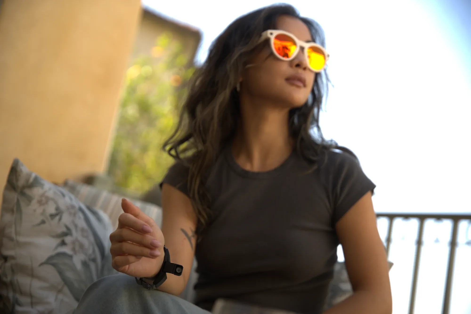 Hands resting on a desk, glasses on, prompting an AI assistant with a pinch.