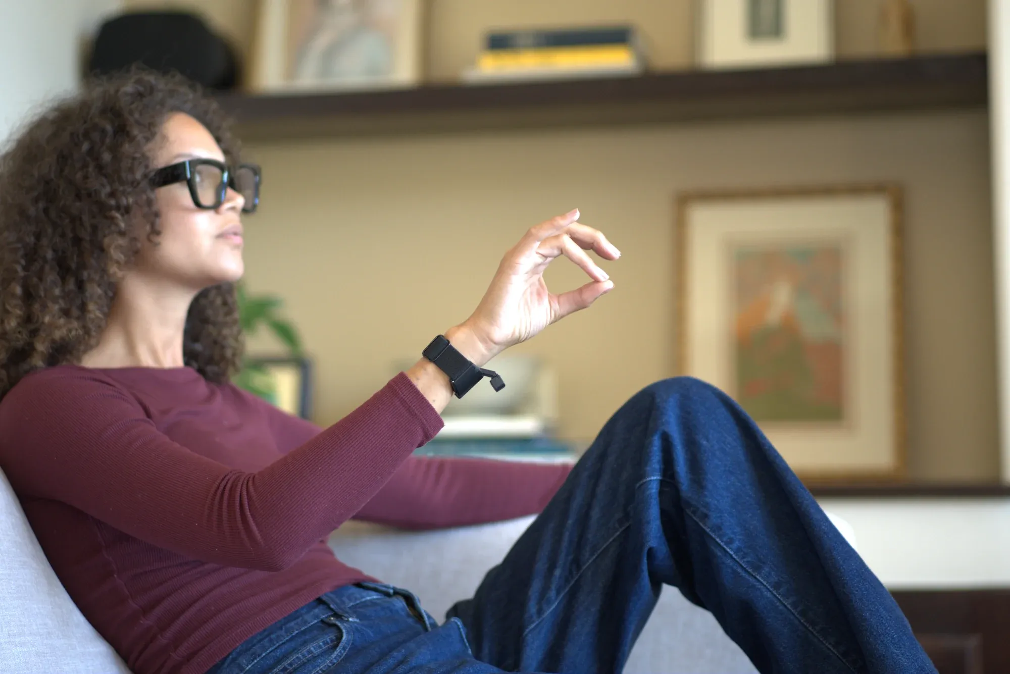 Person in a video meeting, eyes on the screen, hand resting on the table firing a mute gesture.