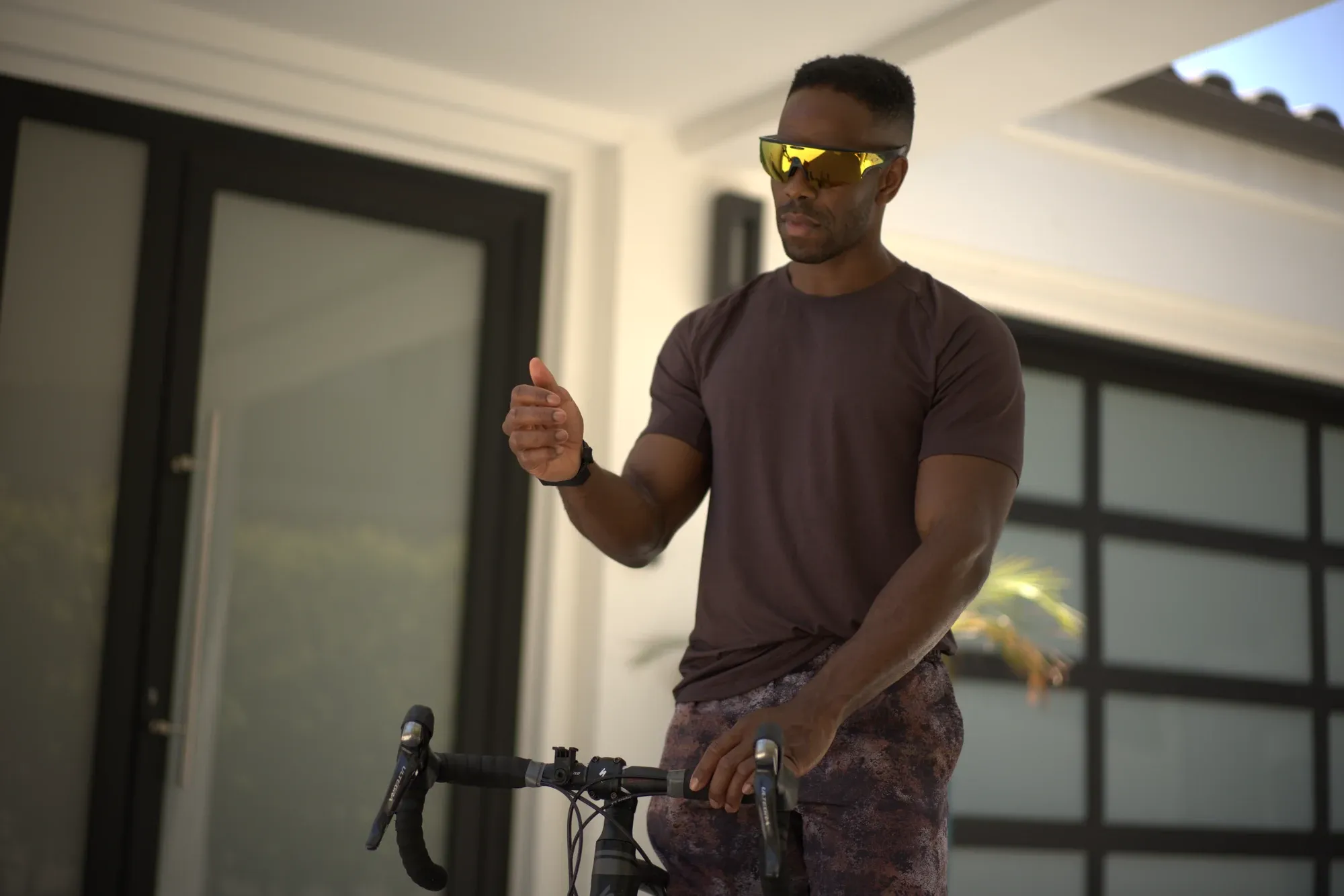 Person walking outdoors with AI smart glasses on, hands free, controlling music and camera from a Tap on their wrist.